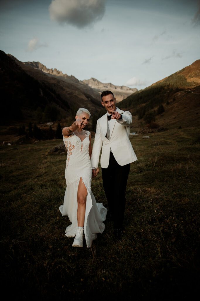 Dolomites elopement photographer  - couple in the mountains pointing at the camera